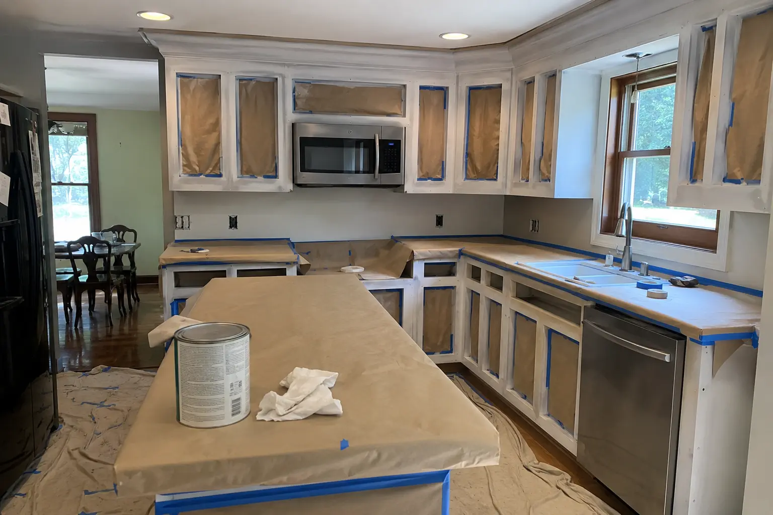 Kitchen cabinet boxes masked and primed during an active cabinet-painting project